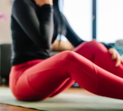 Close-up of yoga mat and water bottle on a wooden floor.